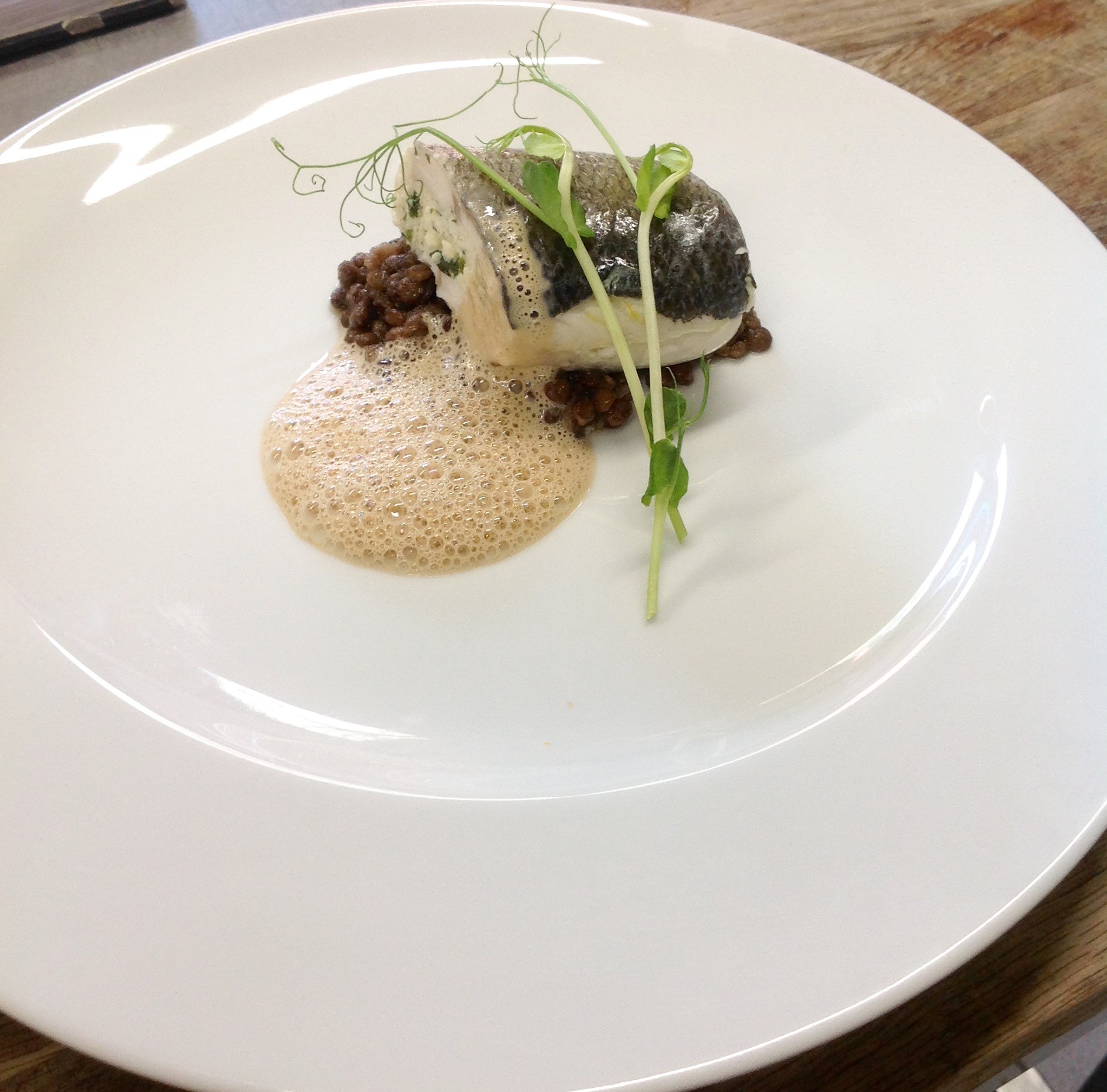 Ballotin de bar aux algues, condiment de lentilles béluga, émulsion à l'ail noire 